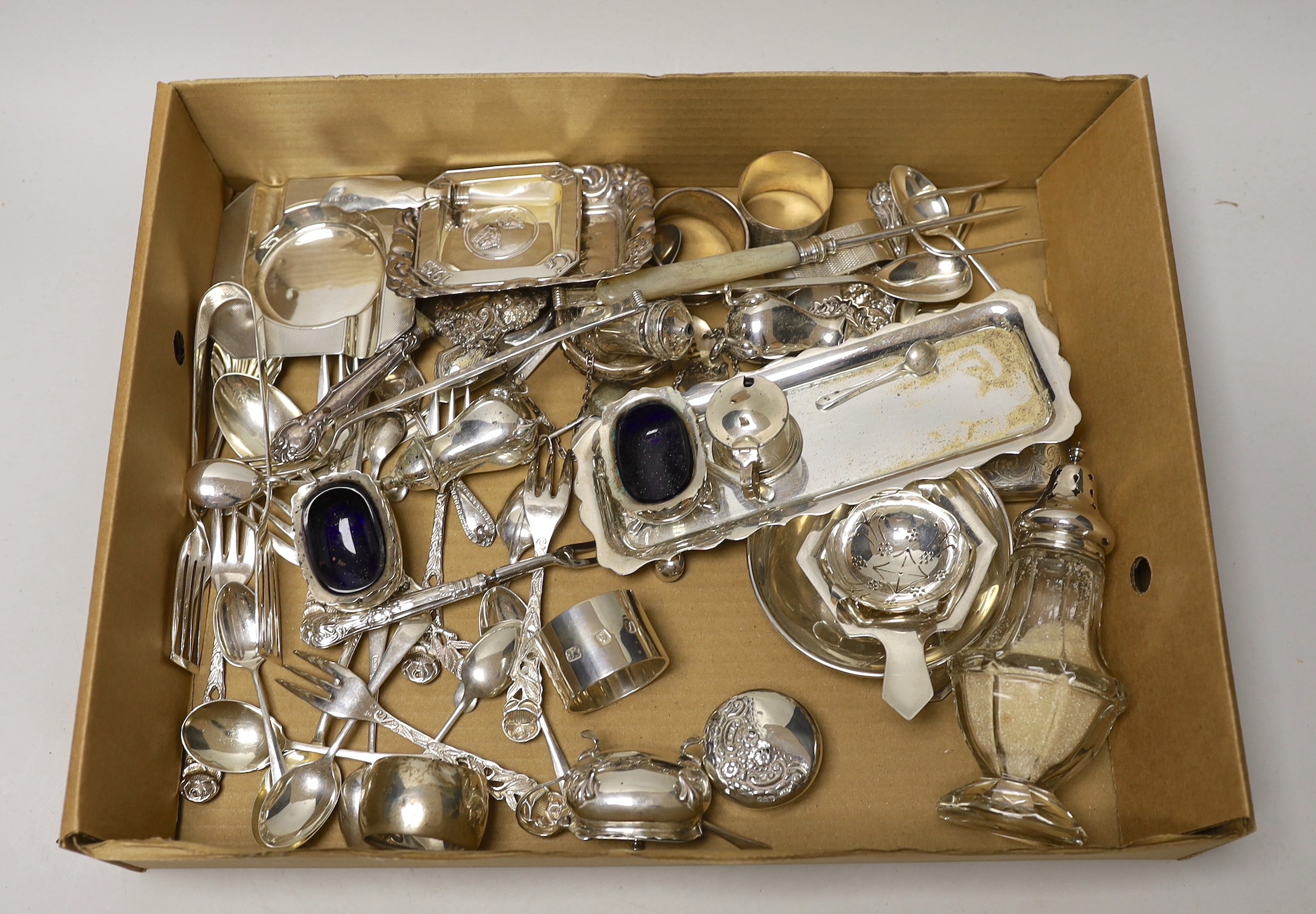 Sundry small silver wares including a cigarette case, two tea strainers, assorted flatware and a condiment set.
